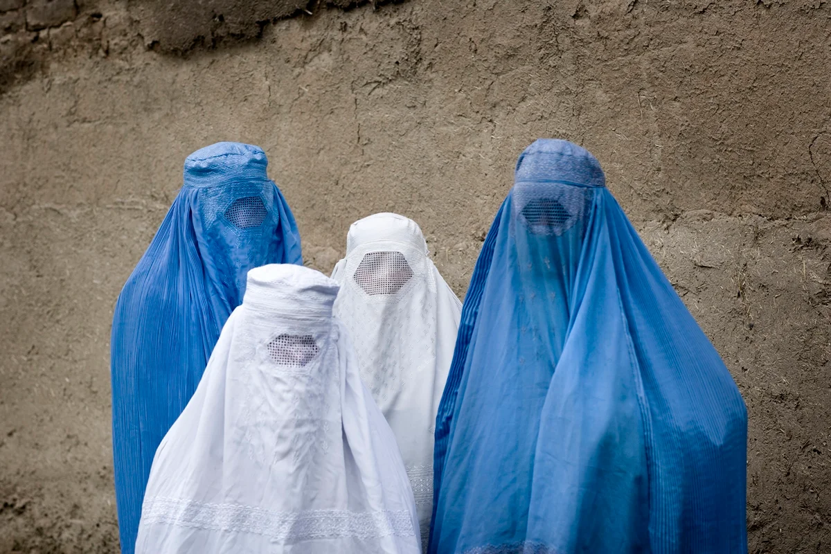 foto com cor. mulheres usando burca azul - metrópoles