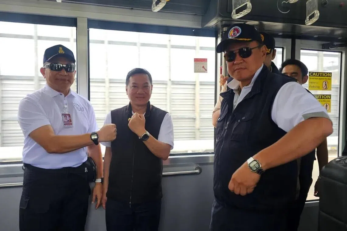 Thai PM Anutin Charnvirakul (right) with Interior Ministry officials showing their watches.