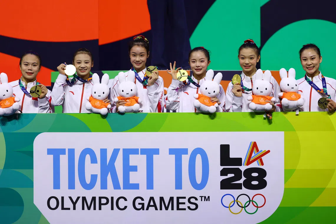 Artistic Gymnastics - 2026 World Artistic Gymnastics Championships - Rotterdam Ahoy, Rotterdam, Netherlands - October 21, 2026 Gold medallist China Team after the Women's Team Final, pose with a banner after qualifying for the LA 2028 Summer Olympics REUTERS/Piroschka Van De Wouw