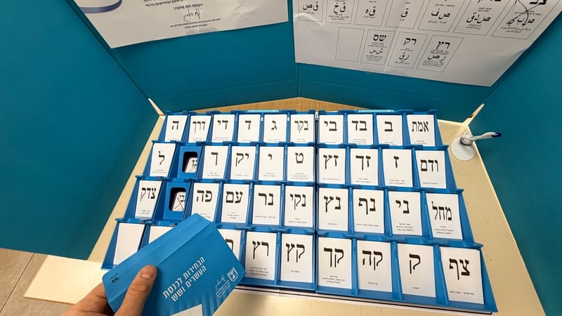 Ballot slips featuring the Hebrew letters and names of political parties are arranged inside a voting booth in Israel