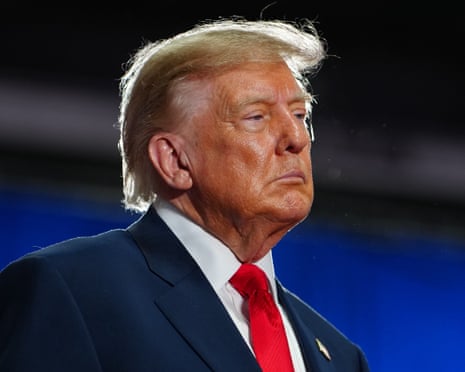 Man in suit at political rally looks ahead with straight face