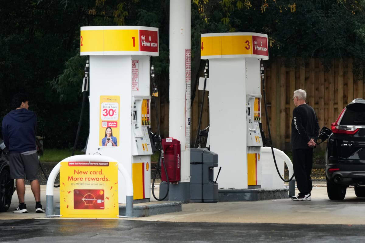 AP Customers check the gas price while they fill up their vehicles in Arlington Heights, Illinois, on September 30.