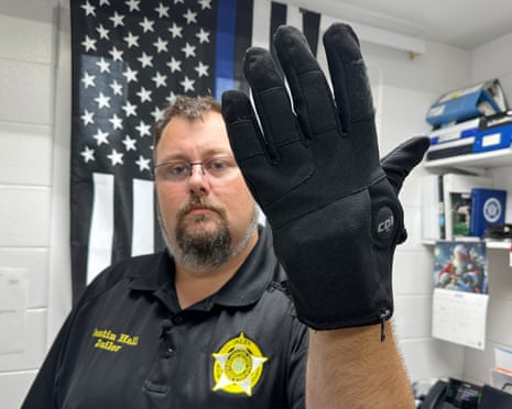 a man in uniform wears a bulky black glove