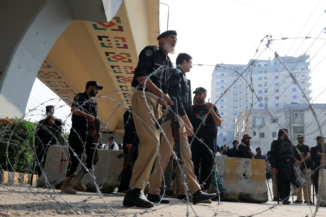 Police guard a road leading to Red Zone, in Peshawar, Khyber Pakhtunkhwa province, Pakistan, on Oct 11.
