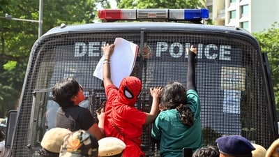 A protester in a Spideman costume climbs onto the front glass of a police bus during a protest seeking Chief Election Commissioner Gyanesh Kumar's resignation over voter roll deletions near Jantar Mantar, in New Delhi on Friday. (ANI)