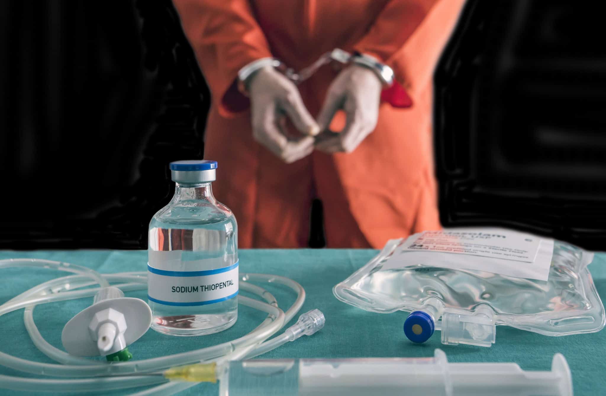 Prisioneiro algemado à morte por injeção letal, frasco com tiopental sódico e seringa em cima de uma mesa, imagem conceitual